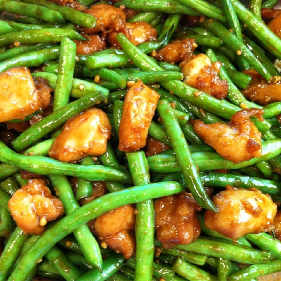 Close-up of Wong's Wok Chinese Kitchen's stir-fried green beans and chicken in a savory sauce.