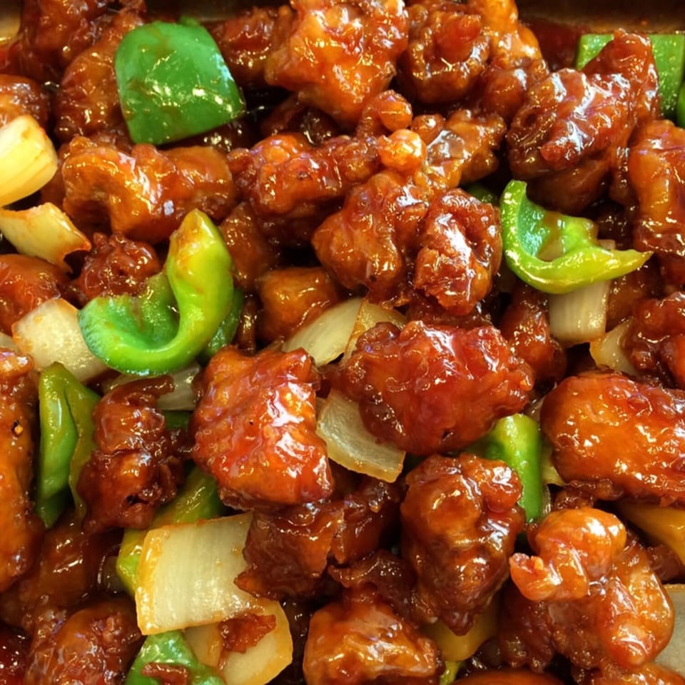Close-up of sweet and sour chicken with green bell peppers and onions from Wong's Wok.